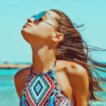 mujer con gafas de sol en la playa